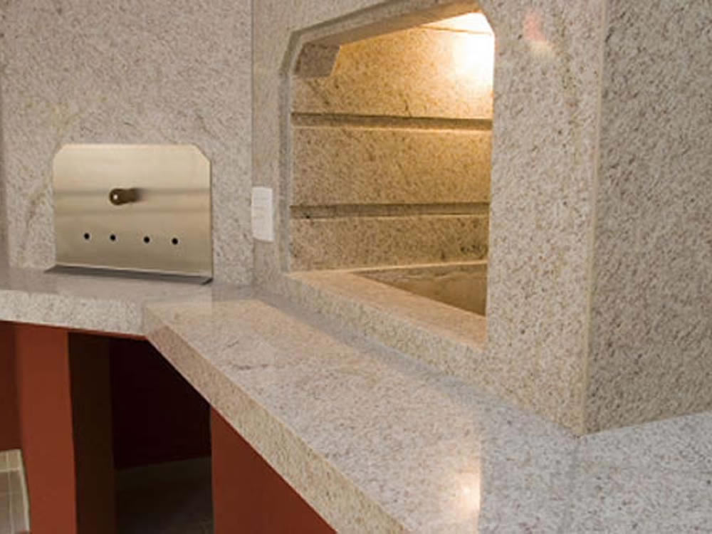 Lareira Aconchegante com Acabamento em Granito Branco e Detalhes Rústicos - ideia