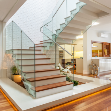 Escada Imponente com Degraus em Silestone Branco e Guarda-Corpo em Vidro - inspiração