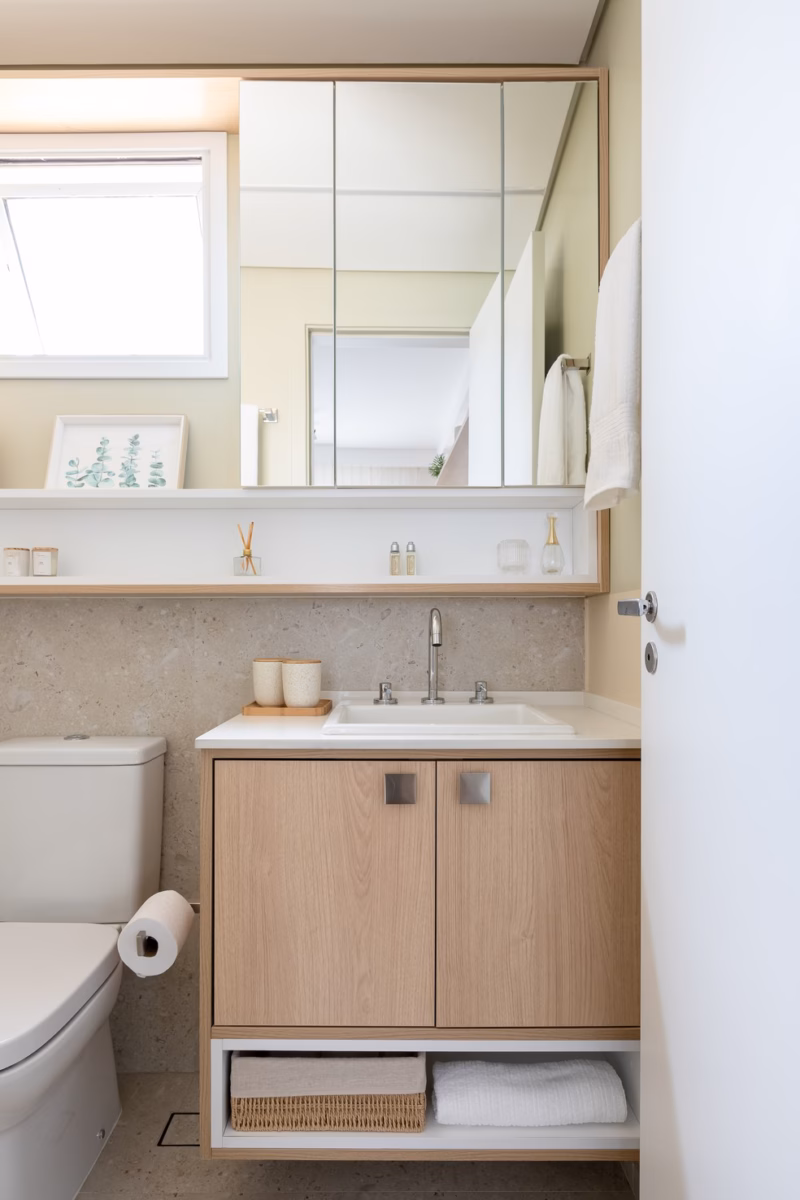 Banheiro Compacto Aconchegante: Madeira Clara e Iluminação Quente - inspiração