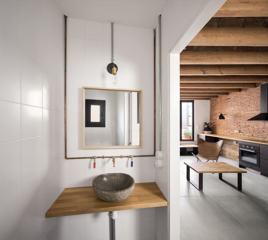 Banheiro Industrial: Tubulações Expostas e Revestimento de Tijolinho - ideia