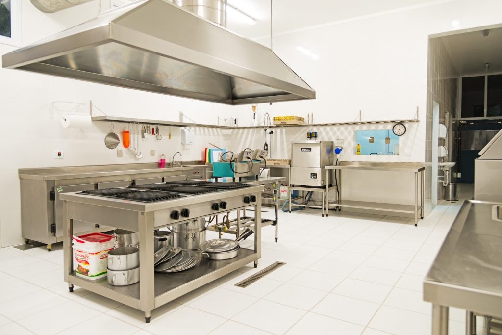 Cozinha Industrial com Integração de Cores Quentes e Equipamentos Modulares - inspiração