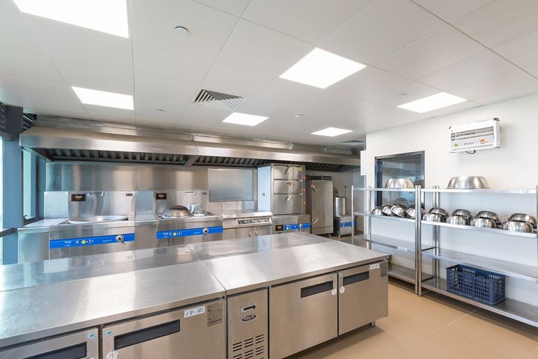 Cozinha Industrial com Integração de Cores Quentes e Equipamentos Modulares - ideia